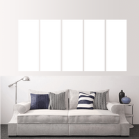 Custom split canvas prints displayed above a modern couch in a stylish living room setting.