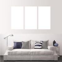 Custom split canvas prints displayed above a stylish sofa in a modern living room setting.