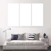 Custom split canvas prints showcased above a stylish gray sofa with decorative pillows.