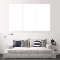 Custom split canvas prints displayed above a modern couch with decorative pillows.