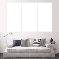 Custom split canvas prints displayed above a stylish couch with decorative pillows, creating a unique wall art experience.