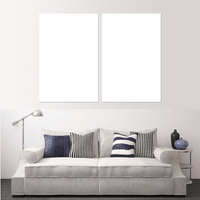 Custom split canvas prints displayed above a stylish gray sofa with decorative pillows.