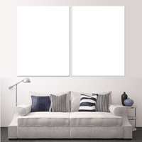 Custom split canvas prints displayed above a stylish couch in a modern living room setting.