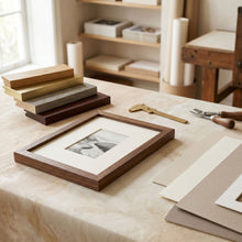 Custom picture framing materials with frame moulding, mat board, and artwork on a studio table.