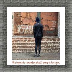 A person facing an old brick wall, staring intently at it. The image is printed on a square canvas and surrounded by a white background resembling a white mat, framed by grey stone. Below the image, a caption reads: 'Me trying to remember what I came in here for.' DigitalFlex Canvas Prints - Germotte, Ottawa.