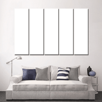 Custom split canvas prints displayed on a wall above a stylish sofa in a modern living room.