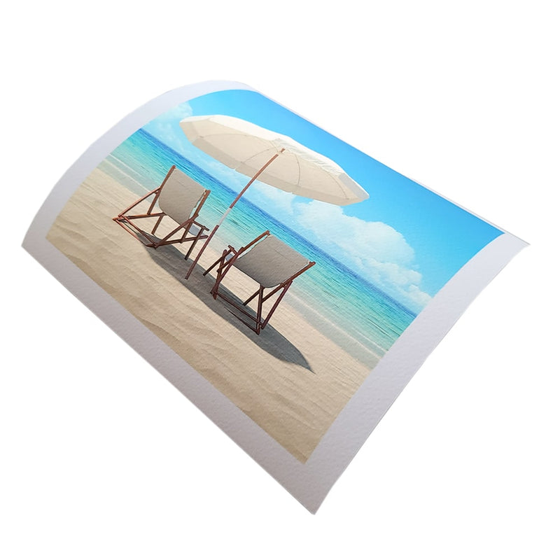 Textured fine art paper prints featuring a serene beach scene with chairs and an umbrella.